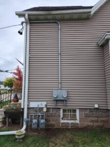 Exterior of a house showing multiple electrical meters and conduit for service upgrades by Apparent Electric LLC in Oshkosh, WI.