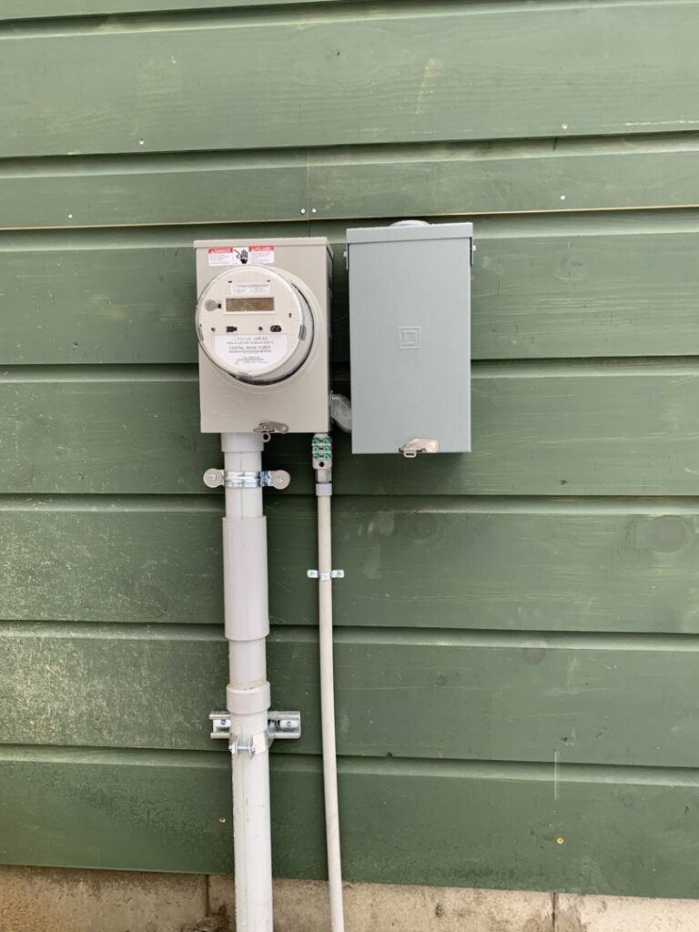 An exterior electrical meter and main disconnect box installation by Building Connections LLC in Auburn, ME.