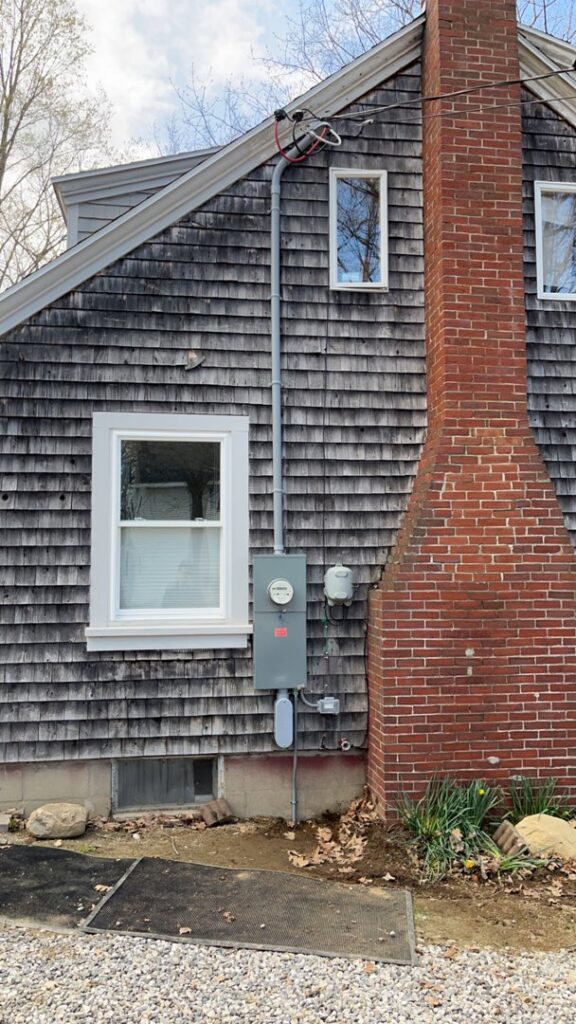 Exterior electrical meter and service entrance conduit on a home, installed by Josh LaFerriere Electric in Westbrook, ME.