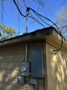 Exterior electrical meter and service mast installation on a building by Ark Electrical Service in Tomball, TX