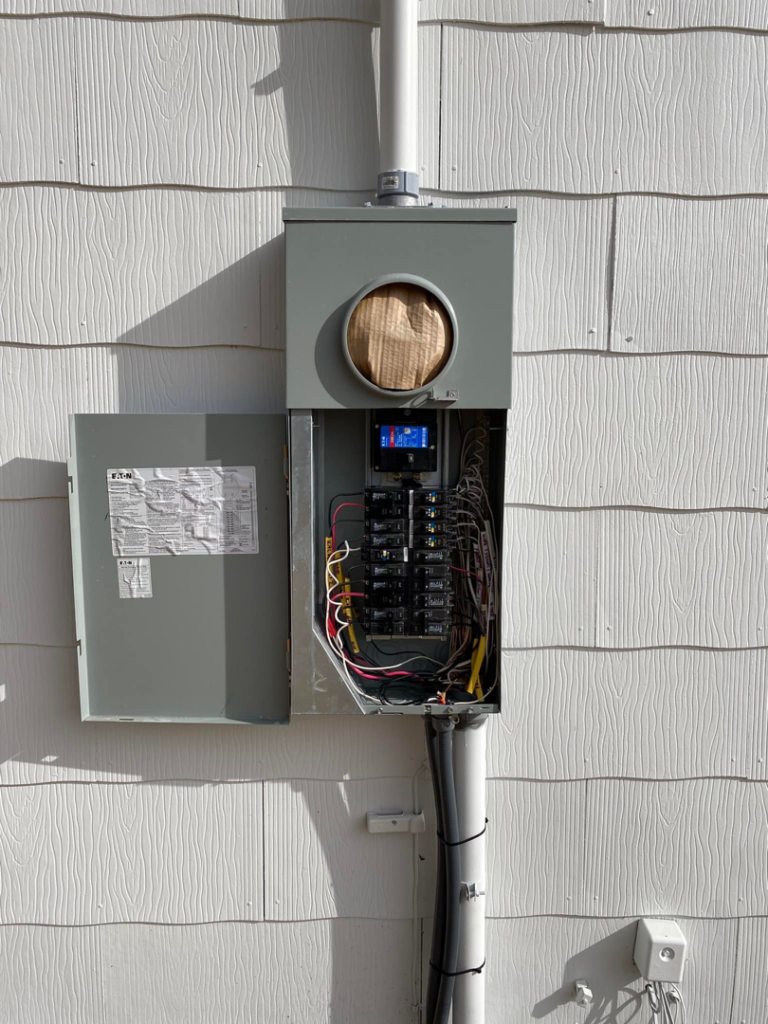 An exterior electrical meter and open service panel installation by WilPower Electrical Services in Charlotte, NC.