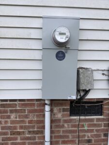An exterior electrical meter and service panel installed by LivElectric in Garner, NC.