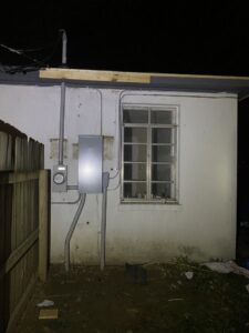 Exterior view of an electrical meter and service panel on a building, maintained by Ross Electric Company in Arlington, TN.