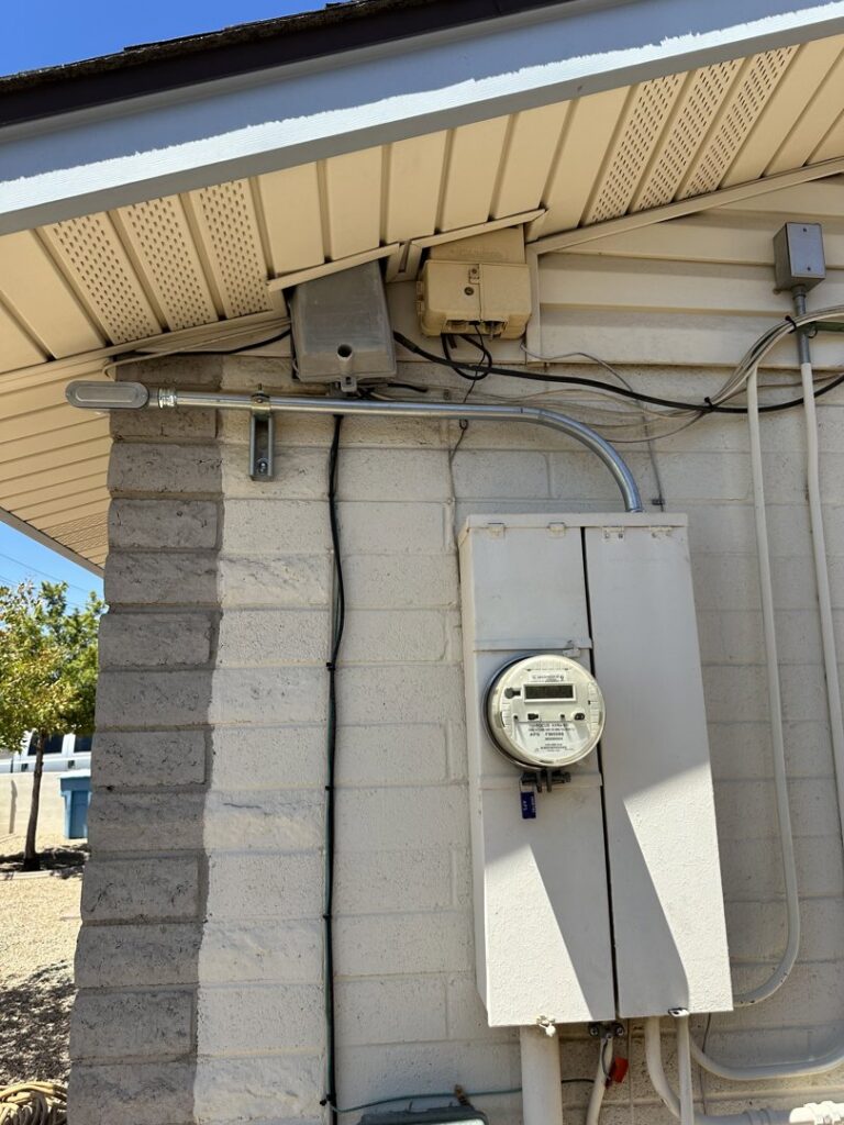 Exterior electrical meter and service conduit installed on a brick wall by Sparks By Rabbit LLC in Scottsdale, AZ.
