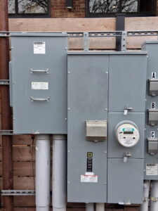 Exterior electrical meters and service panels on a building, installed by Helm Electric in Salina, KS