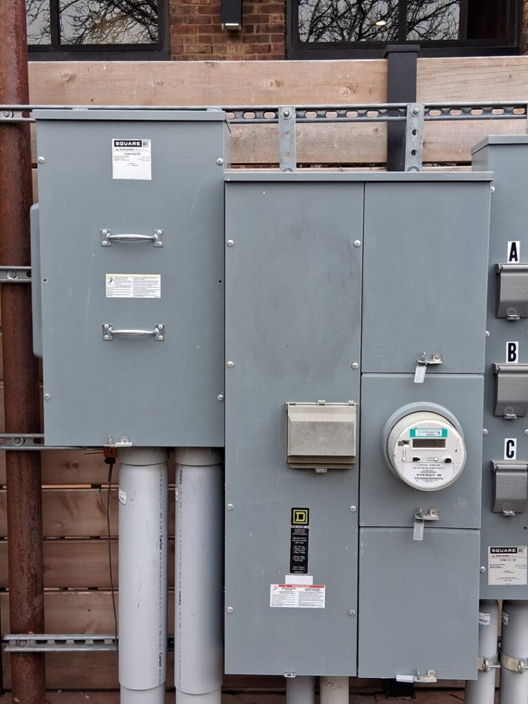 Exterior electrical meters and service panels on a building, installed by Helm Electric in Salina, KS