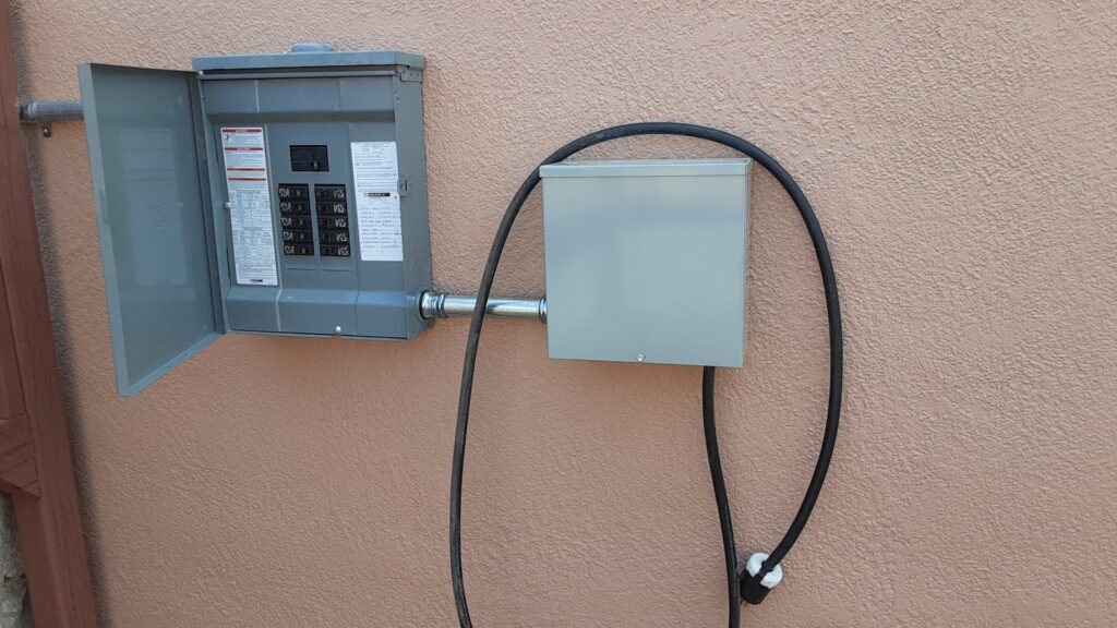 An exterior electrical panel and conduit installed on a building wall by EMT Electric in Las Cruces, NM