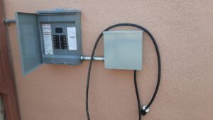 An exterior electrical panel and conduit installed on a building wall by EMT Electric in Las Cruces, NM