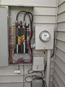 An open exterior electrical panel and meter base showing wiring and breakers, installed by Accuracy Electric Incorporation in Lakewood, CO.