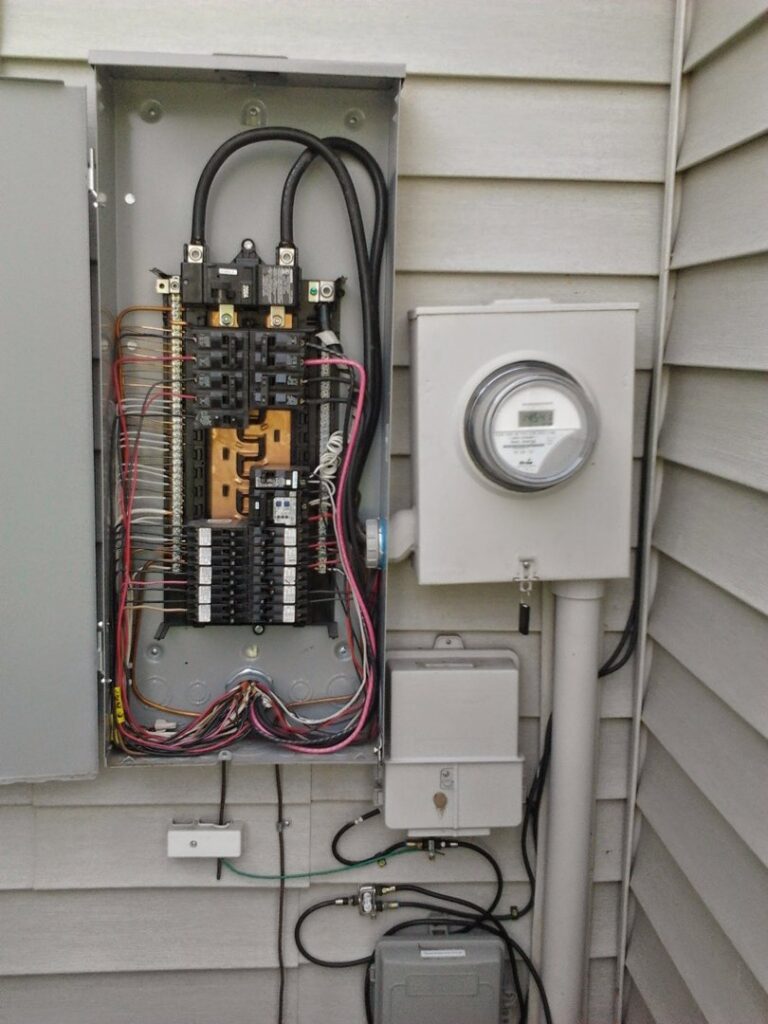 An open exterior electrical panel and meter base showing wiring and breakers, installed by Accuracy Electric Incorporation in Lakewood, CO.