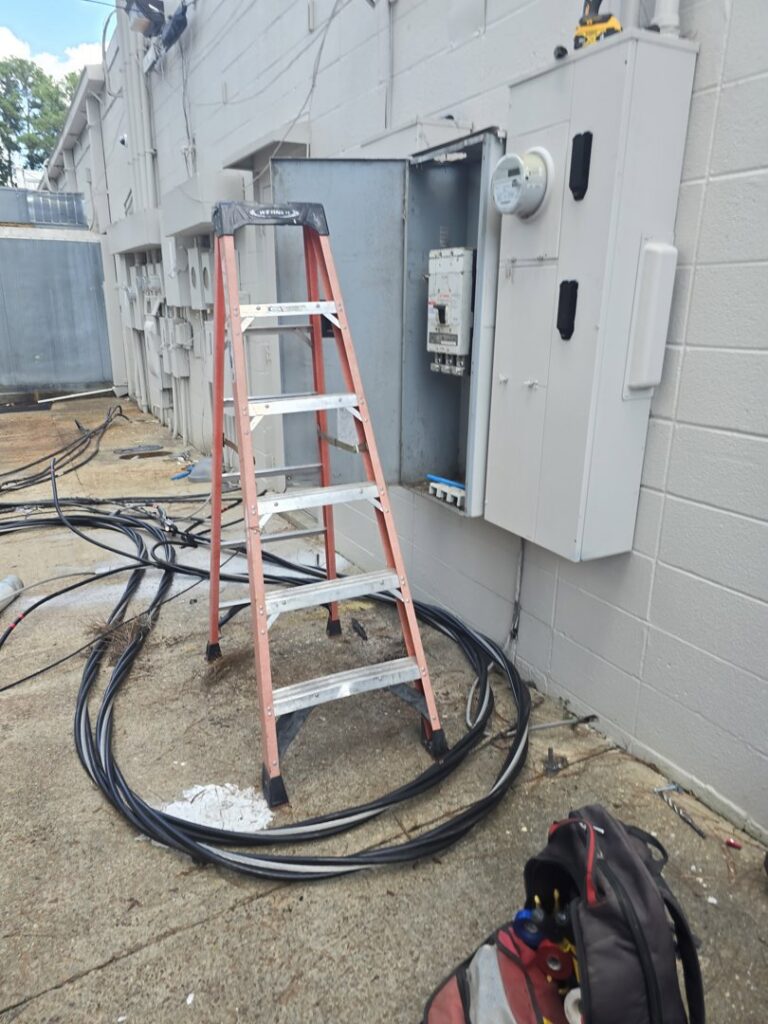 An exterior electrical panel being serviced with cables and a ladder, indicating an upgrade or repair by Apex Electric LLC in Brea, CA.