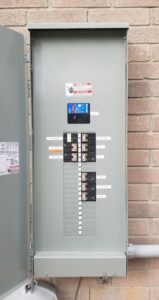 An exterior electrical panel (breaker box) on a brick wall, serviced by Molitor Electric in Austin, TX.