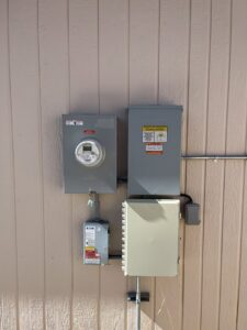 Multiple exterior electrical panels, including a meter and solar system components, installed by Mountain Electric in Knoxville, TN.