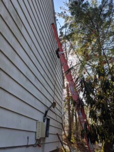 An exterior electrical line repair or installation on a house with a ladder, by York Electric of Westchester in Yonkers, NY.