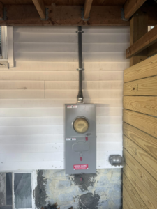 An exterior electrical meter and service disconnect box installed by Joshua Melendez Electrician LLC in New Bedford, MA.