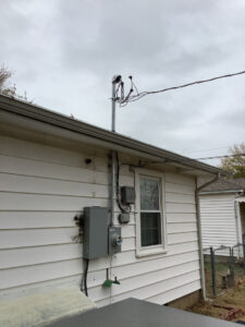 Exterior view of a residential electrical service installation with meter and panel by Electrician Near Me in Broken Arrow, OK.