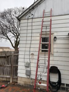 Exterior electrical service upgrade with a ladder and tools by Advance Electrical Contractors in Milwaukee, WI.