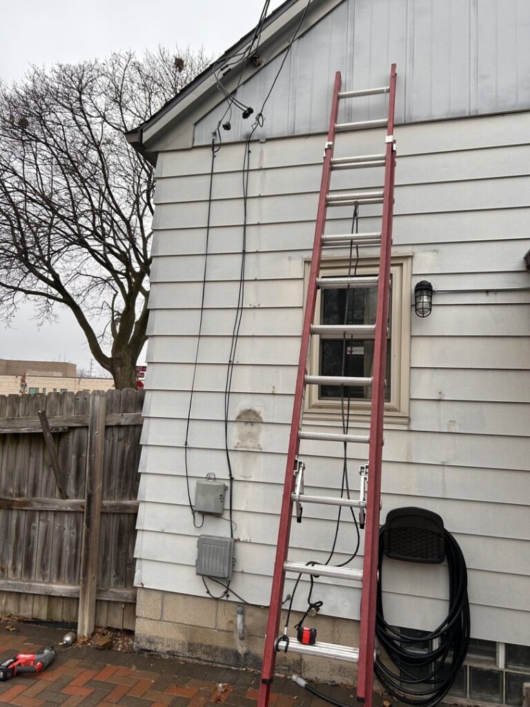 Exterior electrical service upgrade with a ladder and tools by Advance Electrical Contractors in Milwaukee, WI.