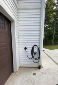An electric vehicle charger installed on the exterior wall of a home by EVC Pro Solutions in Marietta, GA.