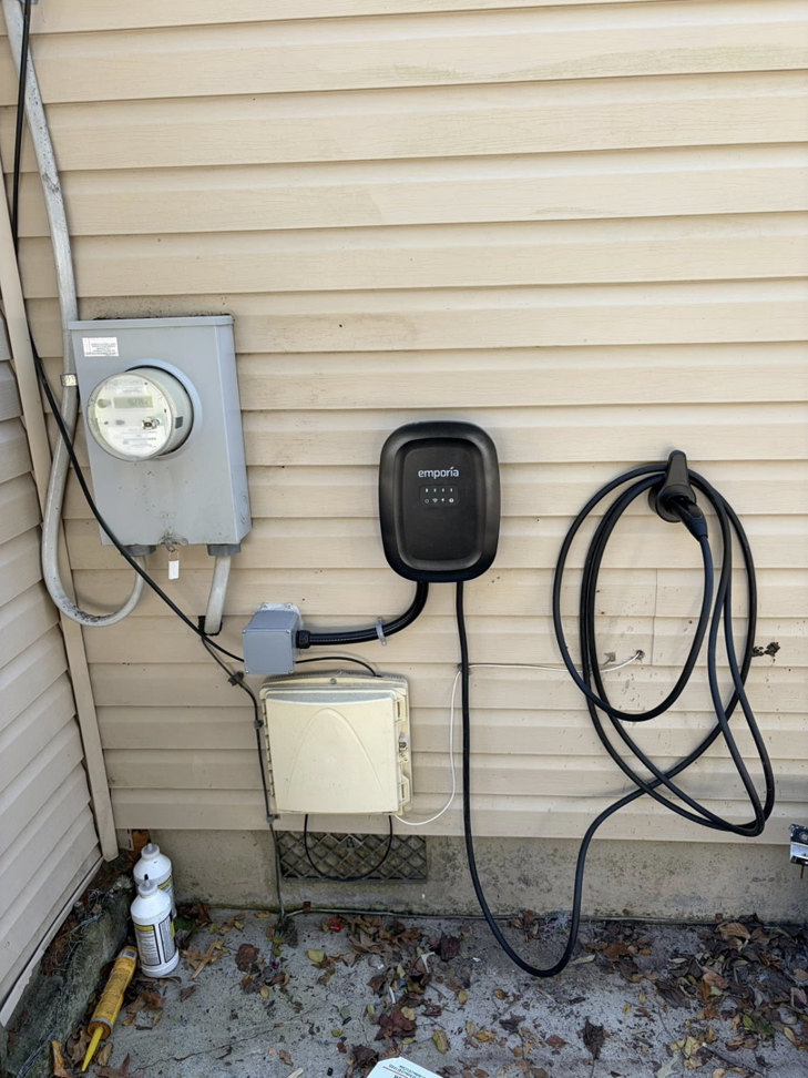 An EV charger installed on an exterior home wall next to an electrical meter, showcasing MLEC's work in Annapolis, MD