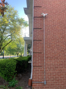 New exterior floodlight and electrical conduit installation on a brick wall by Vera Electric in Aurora, IL.