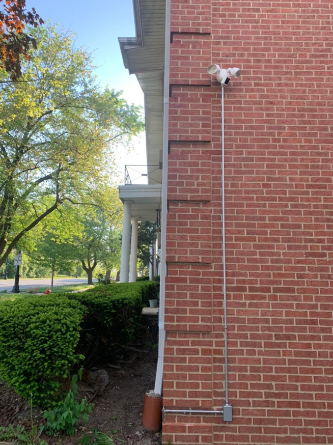 New exterior floodlight and electrical conduit installation on a brick wall by Vera Electric in Aurora, IL.