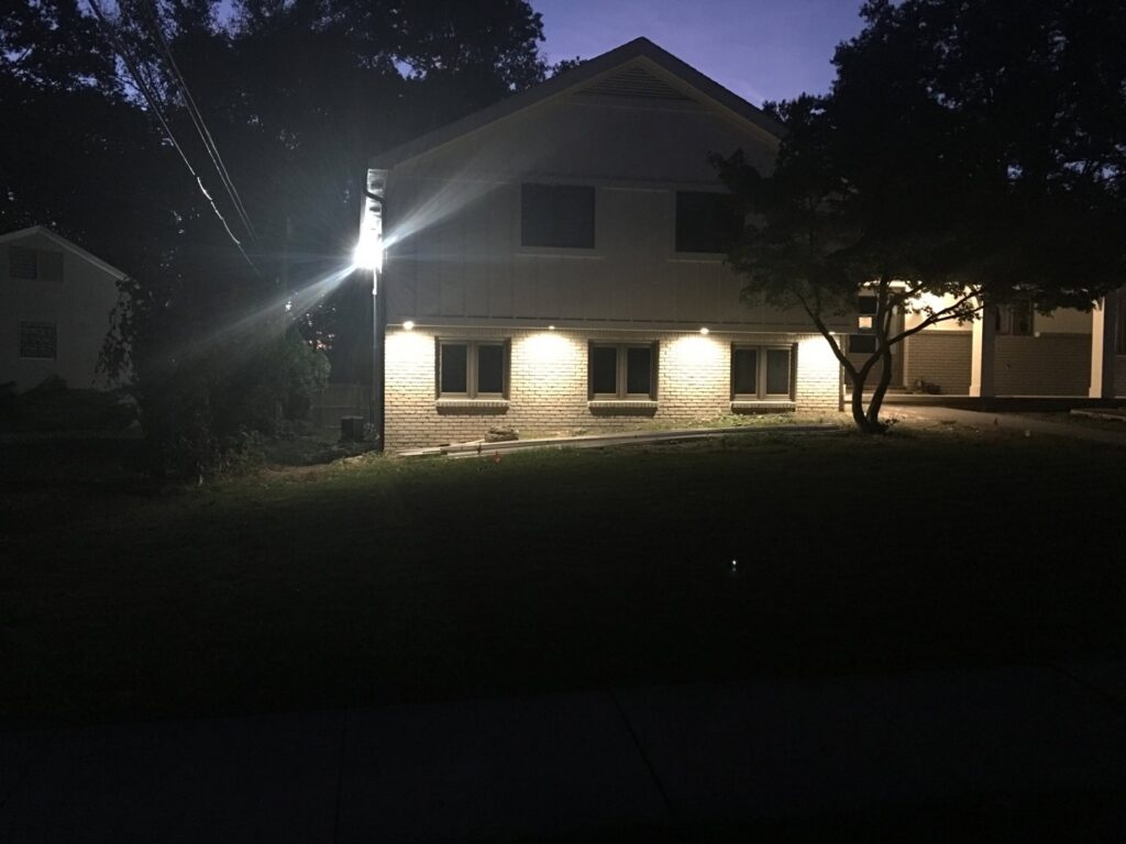 A residential house illuminated by newly installed exterior lighting at night, a service provided by RHS Electrical Services in Westerville, OH.