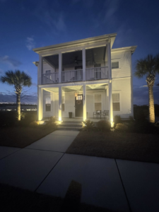 Stunning exterior house uplighting and porch lighting at night, expertly installed by Watts Up Electric LLC in Summerville, SC.