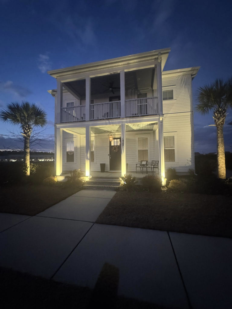 Stunning exterior house uplighting and porch lighting at night, expertly installed by Watts Up Electric LLC in Summerville, SC.