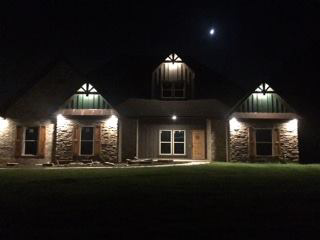 A house at night showcasing new exterior lighting installation by Hammett Electric, Inc. in Conway, AR.