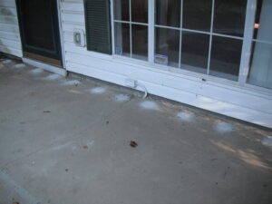 White pesticide dust applied along the exterior foundation of a house for pest treatment by General Pest Solutions in Summerville, SC.