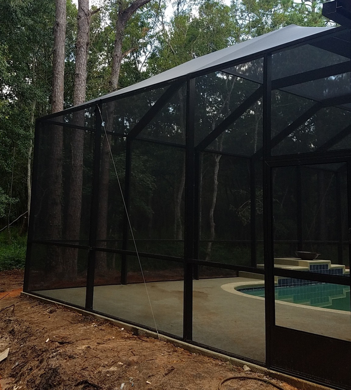 Exterior view of a newly installed pool enclosure and swimming pool by Backyard Paradise in Mobile, AL.