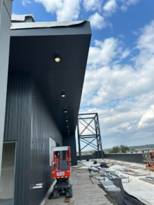 Exterior recessed lighting being installed under an overhang at a construction site by Streff Electric, Inc. in Cedar Rapids, IA