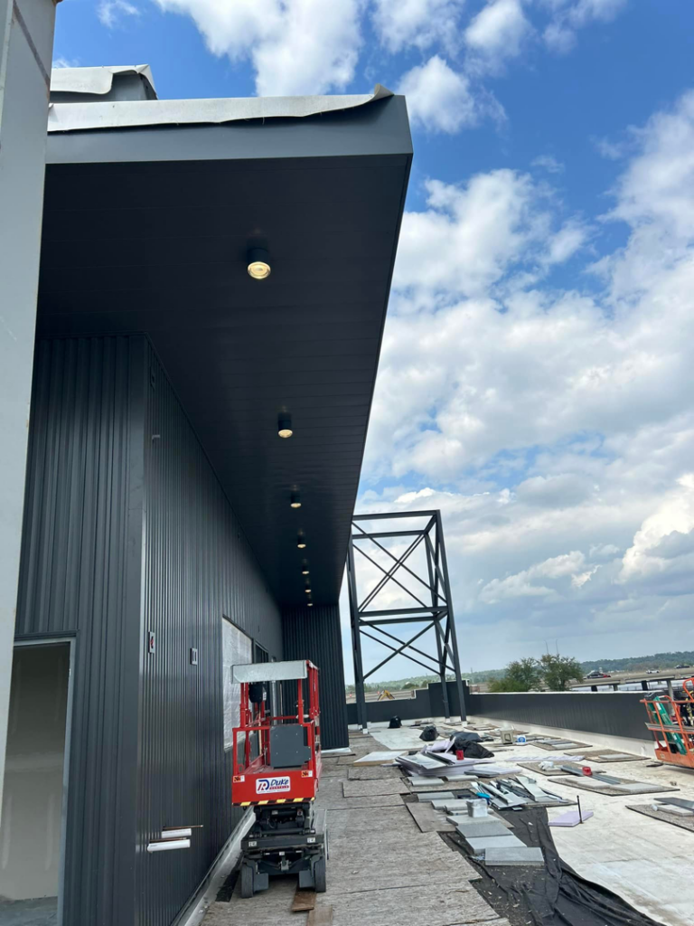 Exterior recessed lighting being installed under an overhang at a construction site by Streff Electric, Inc. in Cedar Rapids, IA