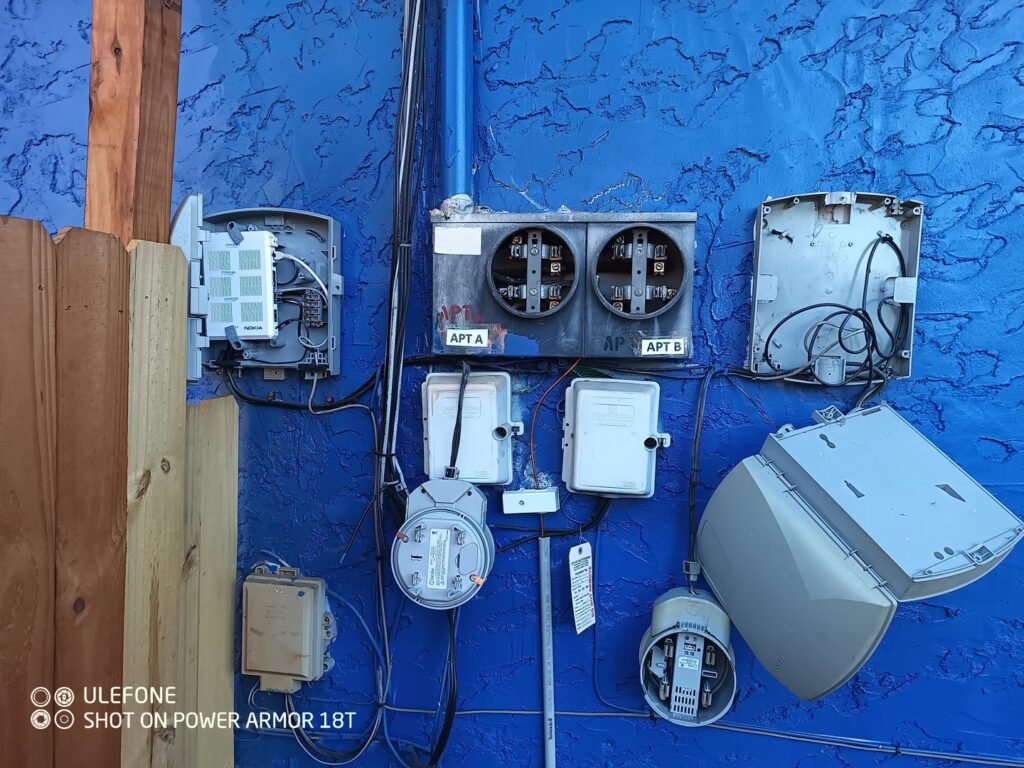 An exterior wall showing multiple utility boxes and electrical service components, serviced by Elemental Electrical in Chattanooga, TN.