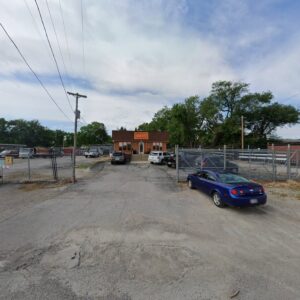 Exterior view of the Kennedy Fence Corporation building and fenced yard in St. Louis, MO, showcasing their services.
