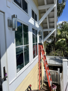 An outdoor wall light fixture being installed on a house exterior by ABD Electric USA in Tampa, FL.