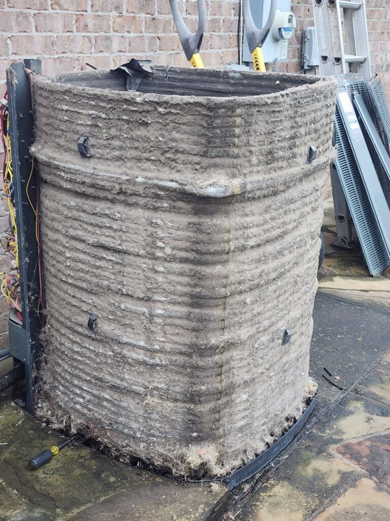 An extremely dirty and clogged outdoor AC coil requiring urgent repair or replacement by Xtreme Heating & Cooling in Tulsa, OK
