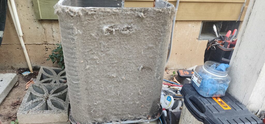 An extremely dirty outdoor air conditioning unit coil needing professional cleaning from Nelke Mechanical in Keizer, OR.