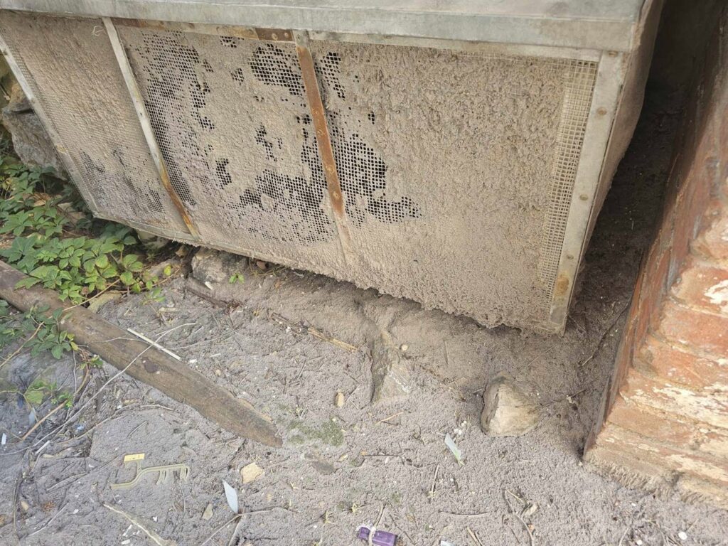 An extremely dirty outdoor AC condenser unit in need of professional cleaning by ReDesign Air in Winchester, VA.