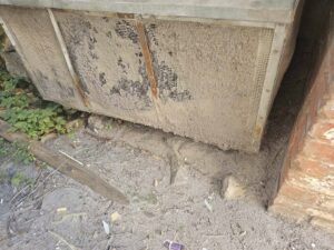 An extremely dirty outdoor AC condenser unit in need of professional cleaning by ReDesign Air in Winchester, VA.