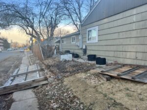 Old, fallen wooden fence panels on the ground, ready for removal or replacement by First Rate Fence & Supply in Denver, CO.