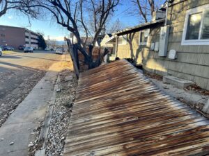 A fallen wooden fence showing damage and a need for repair or replacement by First Rate Fence & Supply in Denver, CO.