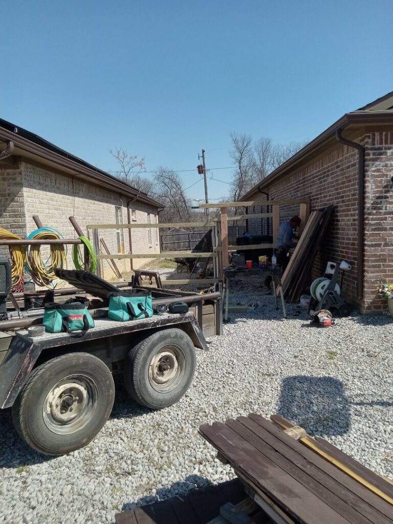 A fence construction site with tools and materials, showing work in progress by Backyard Builders in Rockford, MI.
