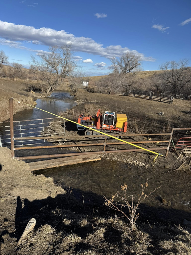 Fence and gate installation project with an excavator by Deer Creek Ag Services, serving Ranchester, WY.