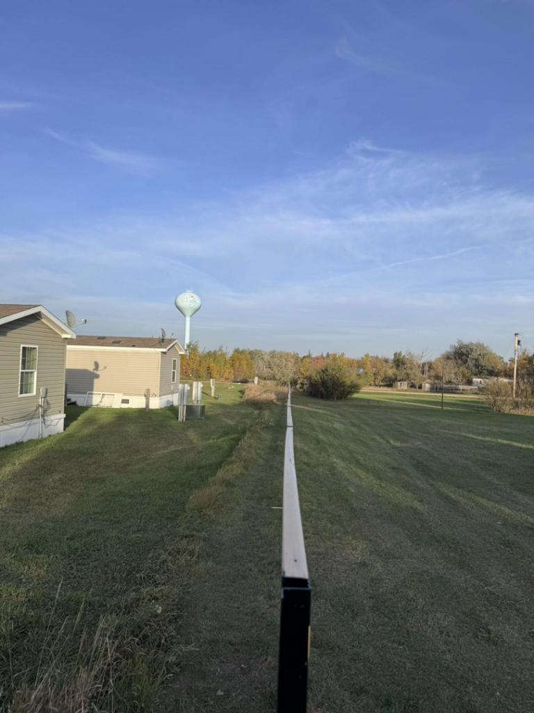 A new fence installation in progress, showing posts and a guide line, by Nailed It Fencing in Williston, ND.