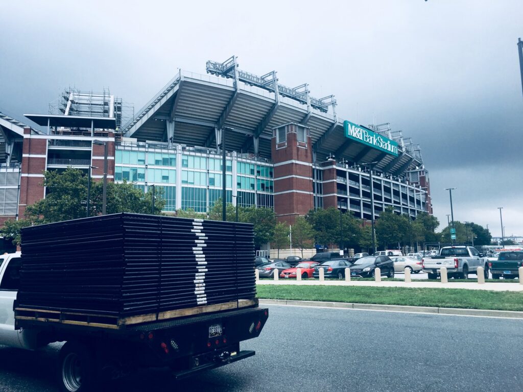 A truck loaded with fence panels for delivery near a stadium by Checkmate Global in Frederick, MD.