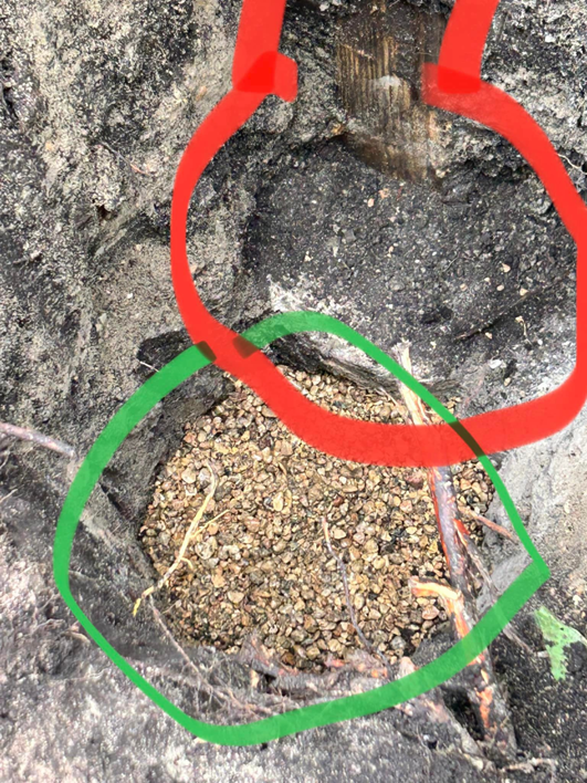 A close-up of a fence post hole with a gravel base, ready for installation by HammerHorn Fence & Gate Systems in Rochelle, IL.