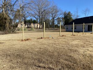 Fence posts being installed with string lines for alignment by Covenant Fence in Columbia, SC.