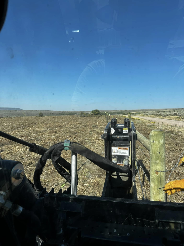 Fence post installation in progress with heavy equipment by Tomahawk Fencing in Riverton, WY.